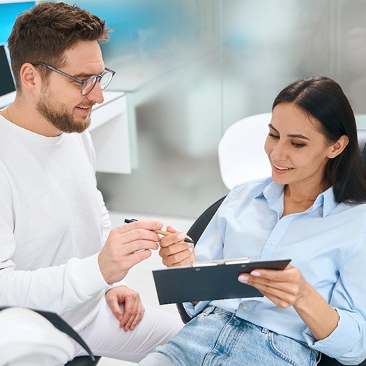 A woman consulting her dentist about treatment costs