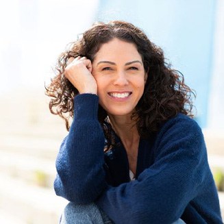 Portrait of happy middle-aged woman sitting outdoors