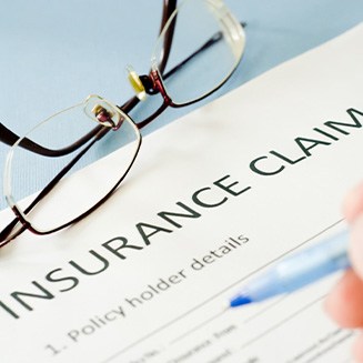 Person filling out insurance claim form