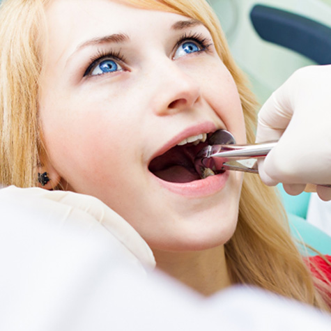 Woman with blond hair undergoing tooth extraction