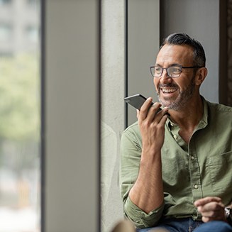 Man smiling while talking on phone