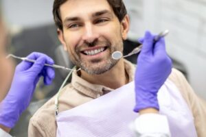 Man learning how to care for his smile at routine checkup