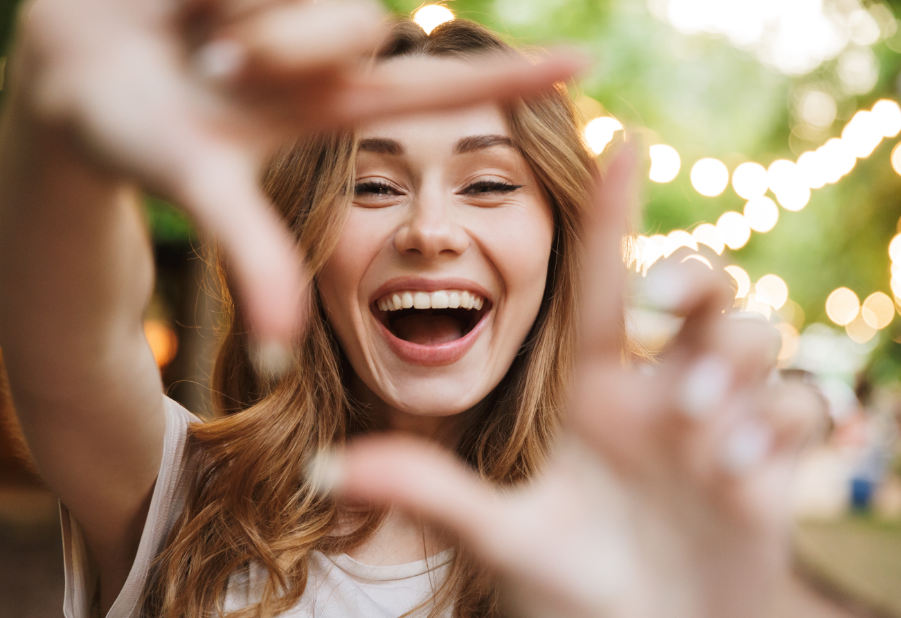 Woman framing smile with hands