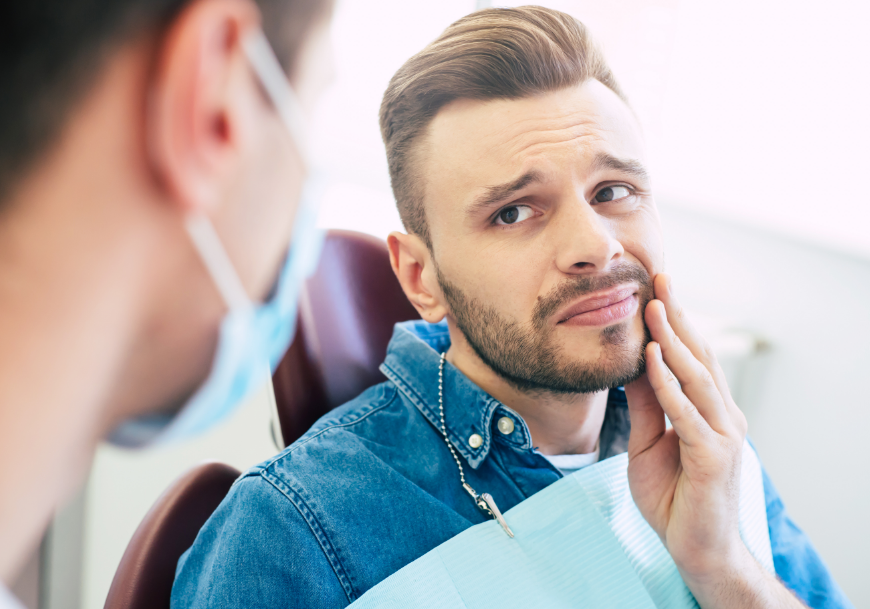 Man holding jaw in pain